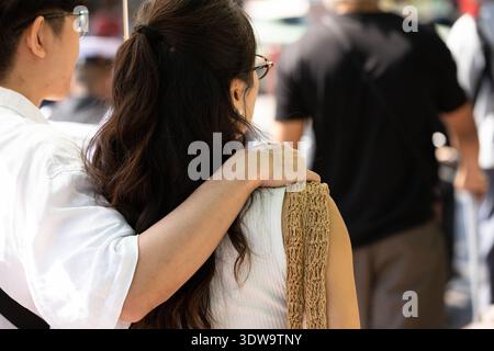 Mann mit der Hand auf der Schulter auf dem Markt, Leute, die im öffentlichen Raum interagieren, Haarstruktur, Nahaufnahme Rückansicht, auf dem Chatuchak Markt. Stockfoto