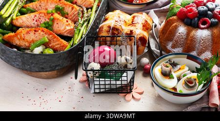 Im Ofen gebratener Lachs mit grünen Bohnen und Spargel zum Osterbrunch oder Abendessen auf hellem Hintergrund. Draufsicht. Stockfoto