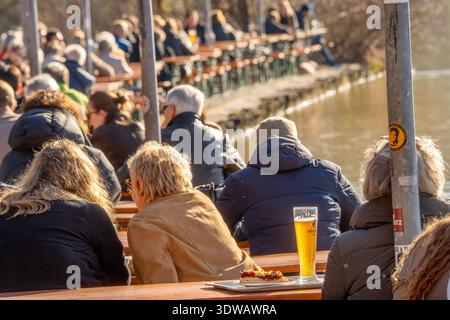 Frühlingsgefühle im Biergarten am Kleinhesseloher See, viele genießen Sonnenschein und Wärme im Englischen Garten, München, Februar 2026 Deutschland, München, Februar 2026, viele Menschen im Biergarten am Kleinhesseloher See, gehören zum Seehaus, Bierbänke am Seeufer, Englischer Garten, Licht, Luft, Sonnenschein, frühlingshafte Temperaturen am Mittwochnachmittag, alle genießen Sonnenschein und Wärme, Temperaturen bis zu 10 Grad, schönes Wetter und es wird täglich wärmer, , Bayern Stockfoto
