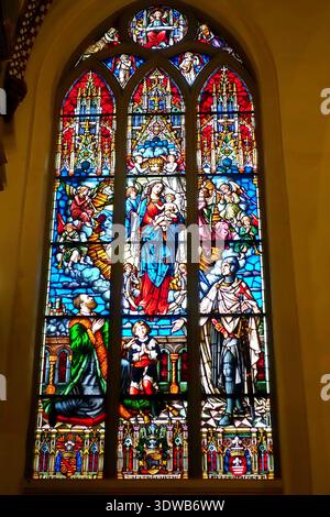 Ein farbenfrohes Buntglasfenster, das die Jungfrau Maria mit dem Christkind in der Rigaer Kathedrale darstellt Stockfoto