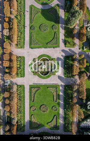 Der Blick aus der Vogelperspektive auf gepflegte Rosengärten mit symmetrischen Mustern und einem zentralen Brunnen bildet einen bezaubernden Wandteppich aus Grün- und Goldtönen, Volksgar Stockfoto