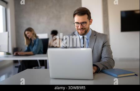 Ein Börsenhändler sitzt am Schreibtisch und analysiert Finanzmärkte und Portfolios Stockfoto