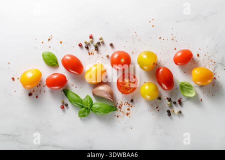 Bunte gemischte Kirschtomaten auf weißem Marmortisch verstreut. Draufsicht mit Kopierbereich Stockfoto