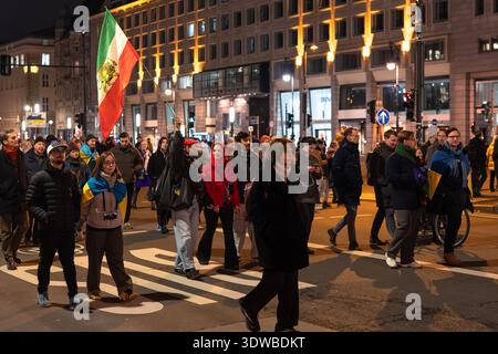 Berlin, Deutschland - 24. Februar 2026: Demonstranten nehmen an einem nächtlichen marsch zur Unterstützung der Ukraine teil, wobei mehrere Menschen ukrainische Fahnen tragen Stockfoto