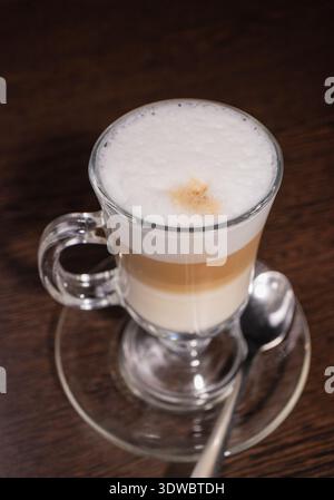 Latte in einer Glasschale auf einem Holztisch Stockfoto