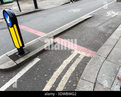 Belebte Manchester Street mit Fahrradspuren, Bordsteinkanten und städtischen Ladenfronten entlang eines grauen Bürgersteigs. Stockfoto