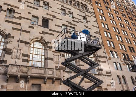 New-York, USA, 1. November 2025: Beleuchtungstechniker bedienen den Scheinwerfer am Scherenlift und beleuchten Fenster während der Filmaufnahme Stockfoto