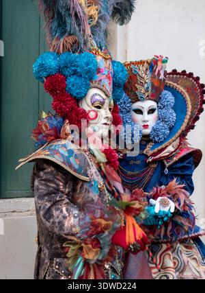 Fotogenes Paar in aufwendigen handgefertigten Kostümen posiert für die Kamera vor der Kirche San Zaccaria während des jährlichen Karnevals in Venedig, Italien. Stockfoto