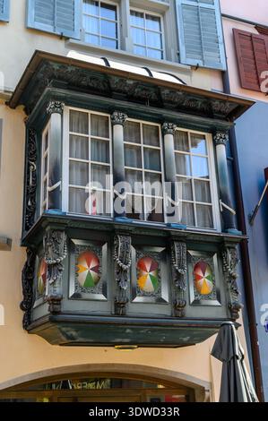 Detaillierter Blick auf einen kunstvoll verzierten Balkon in einem historischen Gebäude in Zürich, Schweiz. Der Balkon ist mit aufwändigen Schnitzereien, dekorativen Medaillons und ausgestattet Stockfoto