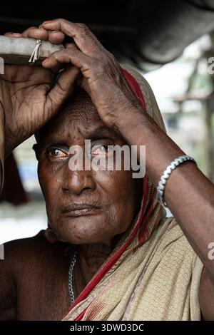 Satkhira, Bangladesch - 12. Juli 2025: Blick auf das verwitterte Gesicht einer älteren Frau, geätzt von Zeit und Belastbarkeit, eingerahmt von den weichen Falten ihres Kopfes Stockfoto