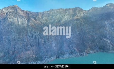 Aus der Vogelperspektive auf die Felsenklippe am Kawah Ijen Vulkan mit türkisfarbenem Schwefelwassersee. Panoramablick auf den Vulkan Kawah Ijen in Ost-Java, Indonesien. Natur l Stockfoto