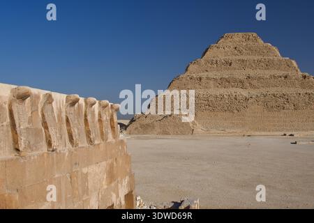 Saqqara Grabkomplex der Djoser Grabkapelle Mauer des Südgrabes mit Frieze von Cobras oben, Stufenpyramide von Djoser und Innenhof Sakqara Ägypten Stockfoto