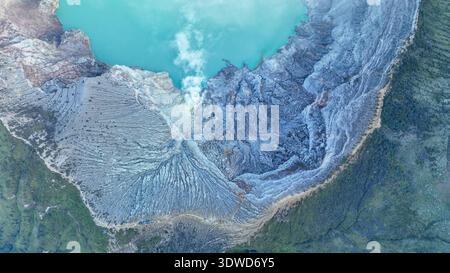 Aus der Vogelperspektive auf die Felsenklippe am Kawah Ijen Vulkan mit türkisfarbenem Schwefelwassersee bei Sonnenaufgang. Panoramablick auf Ost-Java, Indonesien. Natürliche Landschaft Stockfoto