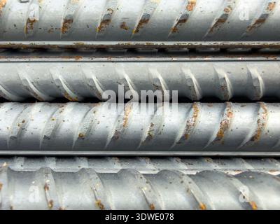 Eine detaillierte Nahaufnahme der strukturierten Eisenstangen mit Metallverstärkung, die ihre geriffelte Oberfläche zeigen, die für den Bau und die strukturelle Unterstützung unverzichtbar ist Stockfoto