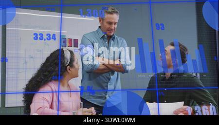 Leitender Manager trägt ein blaues Hemd und präsentiert Kennzahlen am Konferenztisch, hält Papiere und Glas Stockfoto
