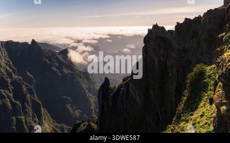 Atemberaubender Sonnenaufgang über den dramatischen Gipfeln Madeiras, die üppige Vegetation und zerklüftete Klippen erfassen. Die Wolken driften sanft und erzeugen ein ruhiges und atmungsaktives Gefühl Stockfoto
