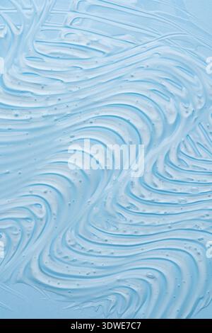 Nahaufnahme einer glatten blauen Gel-Textur mit welligen Linien und kleinen Blasen, die ein abstraktes und beruhigendes Design schaffen. Ideal für Hintergründe und kreative Stockfoto