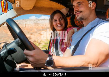 Ein fröhliches Paar genießt ein aufregendes Roadtrip-Abenteuer durch den malerischen Red Canyon in Spanien und fängt dabei das Wesen von Reisen, Erkundungen und toggen ein Stockfoto