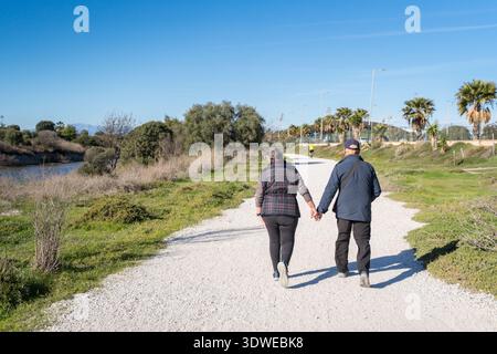 Ein Paar genießt einen friedlichen Spaziergang in der natürlichen Schönheit des Guadalhorce Marshes Nature Reserve in Malaga. Der sonnige Tag zeigt die ruhige Natur Stockfoto