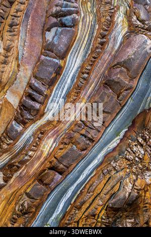 Ein faszinierendes Bild eines Meeresfelsens mit lebendigen, mehrfarbigen Schichten und natürlichen Mustern und Texturen. Ein faszinierender Blick auf geologisches A Stockfoto