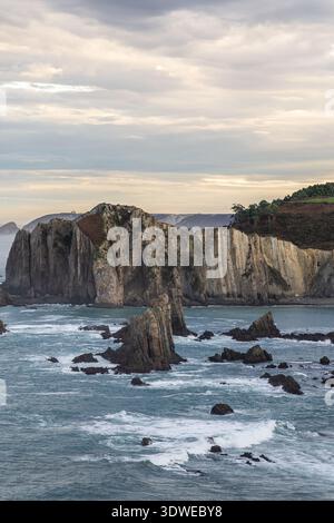 Faszinierende Küstenlandschaft in Asturien, Spanien, mit einer dramatischen felsigen Küste und Wellen, die gegen die Klippen krachen. Ideal für Meeresfotos Stockfoto