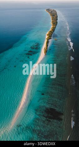 Aus der Vogelperspektive auf ein malerisches maledivisches Atoll mit lebhaftem türkisfarbenem Wasser und üppigem Grün, das die natürliche Schönheit und Ruhe dieses tr zeigt Stockfoto