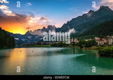 Malerischer Blick auf den Auronzo-See und das Auronzo-Dorf eingebettet in die Dolomiten, italienische Alpen, während eines pulsierenden Sonnenuntergangs. Die malerische Landschaft bietet Ruhe Stockfoto
