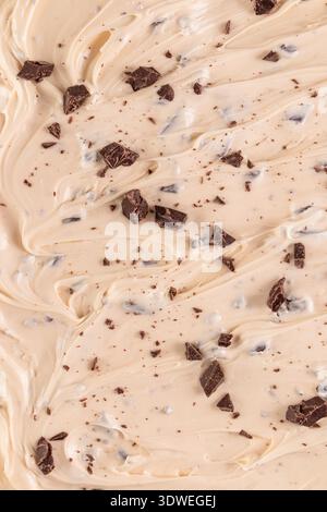 Eine Konsistenz aus cremigem Eis mit Schüsseln von Schokoladencreme und Stückchen. Die reichhaltigen Schokoladenstücke sorgen für Kontrast und Textur und verlockende Chocolate Stockfoto