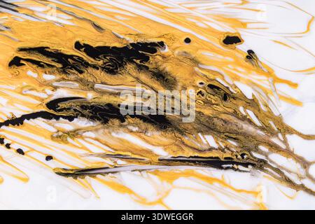 Atemberaubende abstrakte Acrylmalerei mit wirbelnden goldenen und schwarzen Farben, die einen dynamischen, fließenden Hintergrund schaffen. Die Komposition ist sowohl lebendig als auch Stockfoto