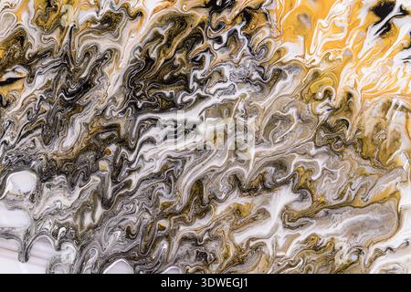 Ein fesselndes abstraktes Acrylbild mit wirbelnden Mustern aus Gold, Schwarz und weiß. Diese dynamische Komposition erforscht Fließfähigkeit und Bewegung Stockfoto