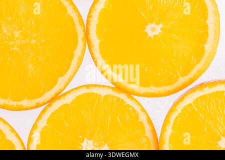 Leuchtende orangefarbene Scheiben auf einem sauberen, weißen Hintergrund, die ihre Frische zum Ausdruck bringen. Diese Früchte sind reich an Vitamin C und eignen sich hervorragend für eine erfrischende Stockfoto