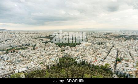 Aus der Vogelperspektive von Athen, Griechenland, mit einer weitläufigen urbanen Landschaft mit dichten Gebäuden, Grünflächen und einem bewölkten Himmel, der einen Blick bietet Stockfoto
