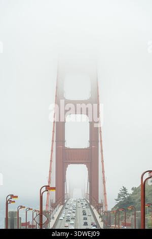 Ein atemberaubender Blick auf San Franciscos berühmte Golden Gate Bridge, teilweise in Nebel gehüllt. Die Brücke steht majestätisch, mit Autos, die über sie pendeln Stockfoto