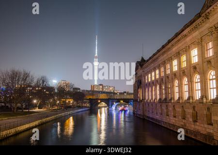 Panoramablick auf die Museumsinsel und den berühmten Berliner Fernsehturm in Deutschland. Die beleuchtete Architektur spiegelt sich wunderbar in der ruhigen Riv wider Stockfoto