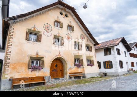 Der Charme des Dorfes Scuol, eingebettet in die Schweizer Alpen. Dieses Bild zeigt wunderschön geschmückte traditionelle Schweizer Häuser mit komplizierten Details und Alp Stockfoto