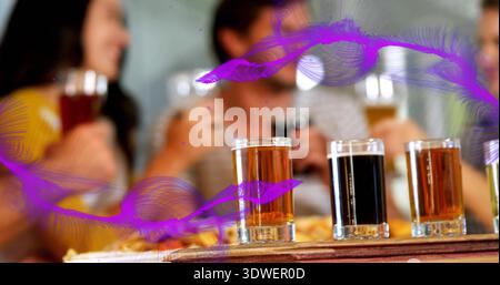 Fokussierender Flug von vier Verkostungsgläsern, die an der Bar in der Brauerei sitzen, mit Senfstreifen hinten Stockfoto
