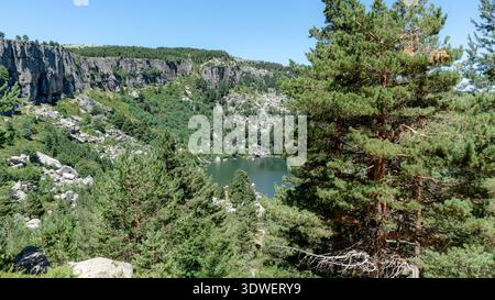 Malerischer Blick auf die Schwarze Lagune in Soria, Spanien, mit üppigen grünen Wäldern und zerklüfteten Klippen. Diese malerische Landschaft ist ein Paradies für Naturliebhaber Stockfoto