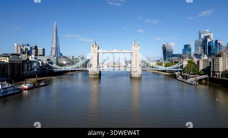 Eine atemberaubende Drohnenaufnahme, die Londons berühmte Tower Bridge über die Themse einfängt. Die moderne und historische Architektur der Skyline bildet einen Stockfoto