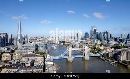 Eine atemberaubende Drohnenaufnahme, die die berühmte Tower Bridge über die Themse in London einfängt. Das Stadtbild umfasst moderne Wolkenkratzer unter Stockfoto