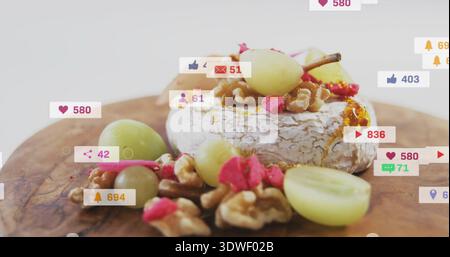 Mit Brie-Rad auf Holzbrett, mit grünen Trauben, Walnüssen, Honig und geselligem Überzug Stockfoto