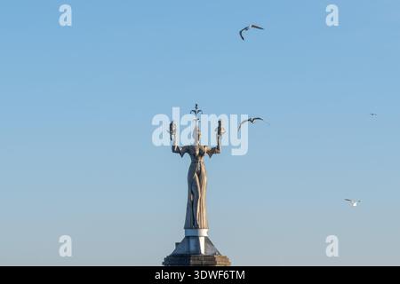 Beschreibung: Die Imperia-Statue im Hafen von Konstanz mit Möwen, die im Winter durch die Luft fliegen. Konstanz, Baden-Württemberg, Deutschland. Stockfoto