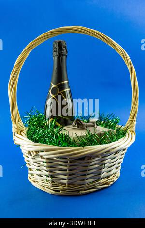 Weihnachtskorb mit einem Geschenk auf blauem Hintergrund. Weihnachtsdekoration und Neujahrsdekoration. Stockfoto