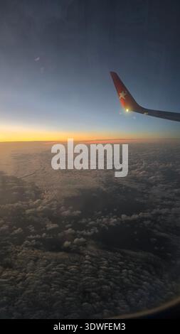 Flugzeug Flügel über Wolken bei Sonnenuntergang Stockfoto
