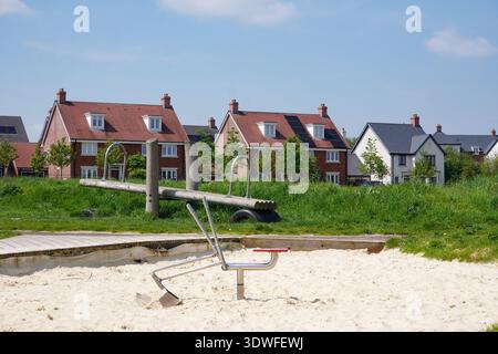 Neues Wohnviertel mit Kinderspielbereich. Vorstadtwohnungen in Großbritannien Stockfoto