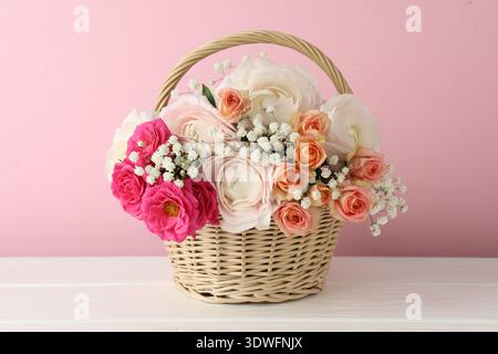 Schöne Blumen im Korb auf weißem Holztisch Stockfoto