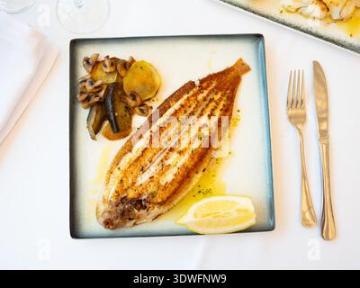 Gebratener Seefisch mit gebackenem Gemüse und Zitrone Stockfoto