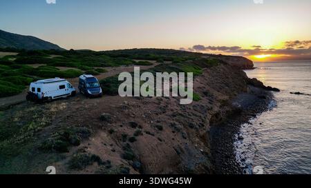 Hochwinkelansicht von zwei Wohnmobilen auf einer wilden Landzunge auf Capo Sperone, Insel Sant'Antioco, Sardinien, Italien. Das Bild erfasst den spiri Stockfoto