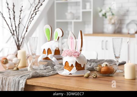 Osterkuchen mit Hasenohren, Kerzen und Eiern auf der Küchenzeile Stockfoto