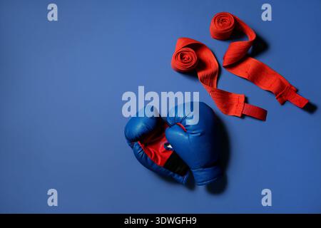 Boxhandschuhe mit Armbändern auf blauem Hintergrund Stockfoto