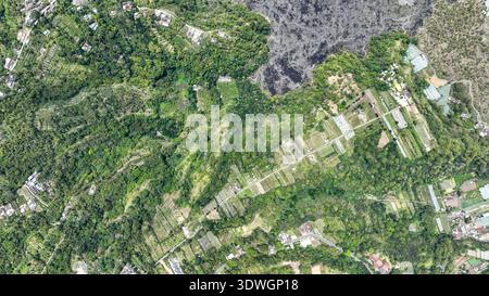 Batur Caldera lebendiges Flickwerk blüht, wo schwarze Lava auf üppige grüne Felder trifft. Präzise Terrassen, verstreute Häuser und verwinkelte Pfade machen die wieder zurück Stockfoto
